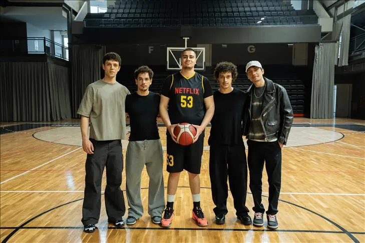 Basketbol salonunda poz veren beş genç; ortadaki Netflix yazılı forma giymiş, elinde top var (seçmelerin tamamlandığı haberin görseli)